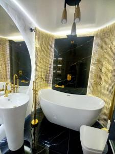 uma casa de banho com uma banheira branca e um lavatório. em Apartament Glamour Okrzei em Sandomierz