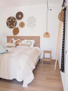een slaapkamer met een bed en een houten vloer bij Casa Narú Albir, duplex appartement met ruim terras en buitenkeuken in Albir