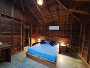 1 dormitorio con 1 cama en una habitación de madera en Cabañas La Tortuga, en Ayampe