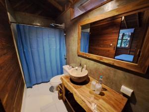 a bathroom with a sink and a toilet and a mirror at Cabañas La Tortuga in Ayampe