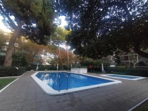 Apartamento céntrico en Salou في سالو: مسبح في ساحه فيها اشجار