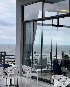 a balcony with chairs and tables and a view of the ocean at Sea View in Astara