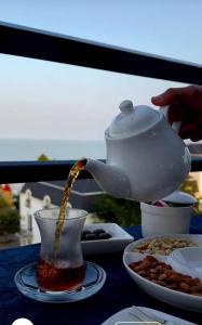 a teapot pouring tea into a cup on a table at Sea View in Astara