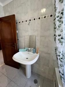 Victoria Superb Rooms في Arrentela: حمام مع حوض أبيض ومرآة