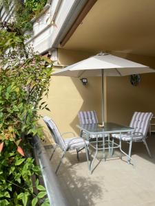 a patio with a table and chairs and an umbrella at Stanza Eur Tintoretto in Rome