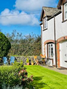 a garden with chairs and a house at Honeysuckle Cottage in Ilfracombe
