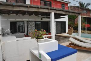 un patio de una casa con mesa y sillas en +221 Lagune Beach House, en Mbodiène