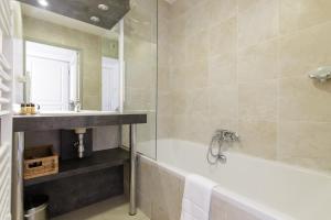 ein Badezimmer mit einer Badewanne und einem Waschbecken in der Unterkunft Greg YourHostHelper in Cannes