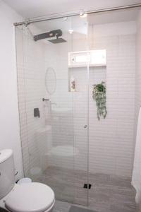 een badkamer met een glazen douche en een toilet bij Soare Country house in Zipaquirá