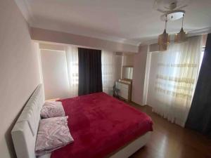 Duplex apartment next to airport في Arnavutköy: غرفة نوم بسرير كبير مع بطانية حمراء