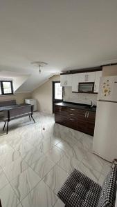 Duplex apartment next to airport في Arnavutköy: غرفة كبيرة مع مطبخ مع ثلاجة