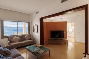 a living room with a couch and a television at Las Rocas Beach-Ciutat Jardi Playa in Palma de Mallorca