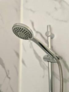 a shower with a shower head in a bathroom at Gloucester Serviced Apartments in Gloucester
