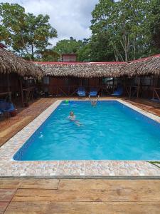 una persona en la piscina de un complejo en Avatar Amazon Lodge & Canopy Park en Santa Teresa