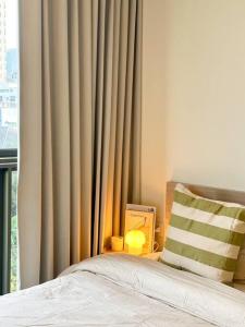 a bedroom with a bed and a lamp and a window at Cozy Room in Bangkok, BTS Onnut (E9) Station in Bangkok