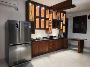 a kitchen with a stainless steel refrigerator and wooden cabinets at "The Anchorage" of Field View in Pannipitiya