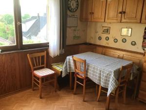 een keuken met een tafel en stoelen en een raam bij Maison individuelle dans les Vosges du nord in Niederbronn-les-Bains