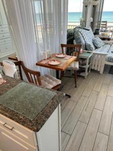 a kitchen with a table and chairs and the ocean at OB Oceanfront Studio - closest to the beach in Ormond Beach