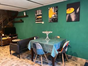 una sala da pranzo verde con tavolo e sedie di CASA MUPI a SantʼEufemia a Maiella