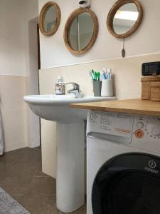 a bathroom with a sink and a washing machine at Casa in pietra al lago di Como in Colico