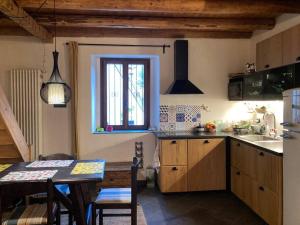 a kitchen with a table and a table and a window at Casa in pietra al lago di Como in Colico