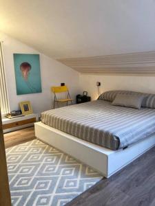 a bedroom with a large bed and a yellow chair at Casa in pietra al lago di Como in Colico