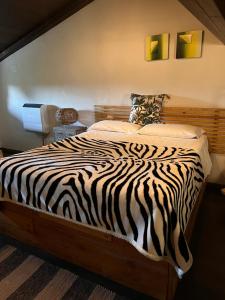 1 cama con estampado de cebra en un dormitorio con pared en CASA MUPI en SantʼEufemia a Maiella