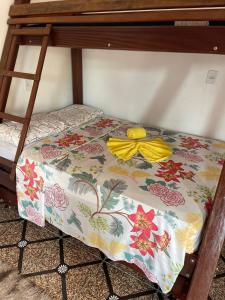 uma cama com um lençol florido no beliche de baixo em Pousada Sossego de Alter em Alter do Chão