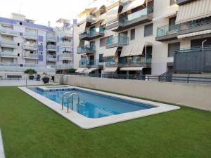 un apartamento con piscina frente a un edificio en Apartamento Playa de Xilxes., en Moncófar