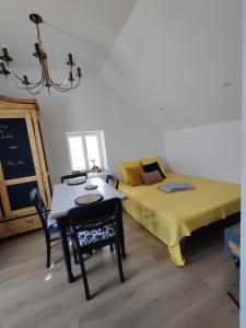 a room with a bed and a table and a table and chairs at Appartement Cosy in Sausheim