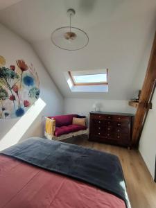 - une chambre mansardée avec un lit et un canapé dans l'établissement Appartement Cosy, à Sausheim