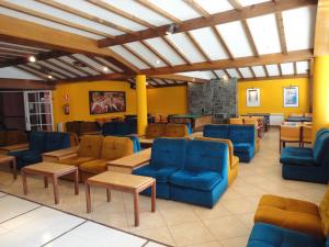 a waiting room with blue chairs and tables at Apartamentos Sarga Sentirgalicia in Cabañas