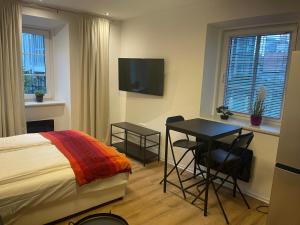 een slaapkamer met een bed, een tafel en een televisie bij Celje Luxury Apartments & Spa in Celje