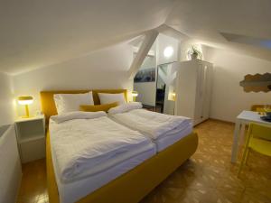 a bedroom with a large bed and a table at Small but Charming-Yellow Appartement in Baden