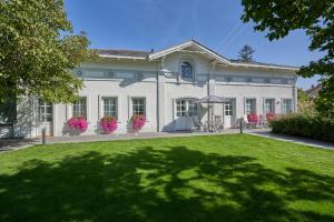 a large white house with a lawn in front of it at Small but Charming-Yellow Appartement in Baden
