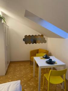 sala de estar con mesa blanca y sillas amarillas en Small but Charming-Yellow Appartement, en Baden
