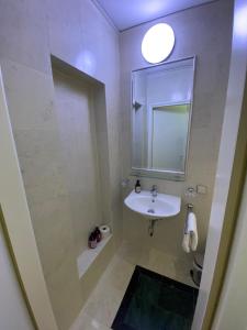 Baño blanco con lavabo y espejo en Small but Charming-Yellow Appartement, en Baden