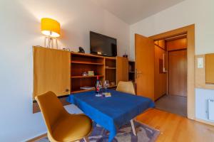 un soggiorno con tavolo e sedie blu di Appartamento Indaco Armonya a Merano