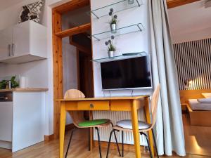 Kleines Apartment mit einem Schreibtisch und einem TV in einem Zimmer. in der Unterkunft beliebtes City-Apartment Reutlingen in Reutlingen