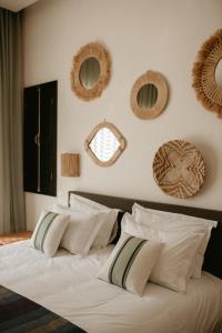 - une chambre dotée d'un lit avec des oreillers et des miroirs au mur dans l'établissement Villa Aljana Marrakech, à Marrakech