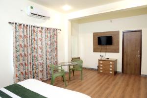 Habitación de hotel con cama, mesa y sillas en Hotel Tree of heaven, en Udaipur