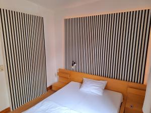 a bedroom with a white bed and a large window at beliebtes City-Apartment Reutlingen in Reutlingen