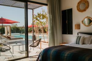 - une chambre avec un lit et une terrasse avec une piscine dans l'établissement Villa Aljana Marrakech, à Marrakech