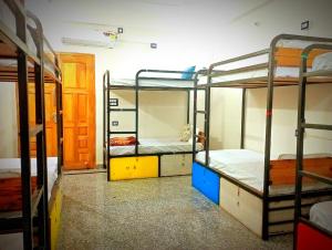 a room with three bunk beds and a door at Srinivasan Villa in Varanasi
