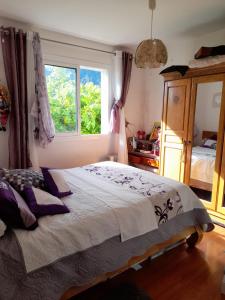 una camera con un grande letto e una finestra di Maison de charme, en Plaine Poésie -chez l'habitant- a La Plaine-des-Palmistes