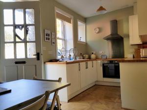 a kitchen with a table and a stove top oven at Birchwood Cottage - In the Heart of Wooler in Wooler