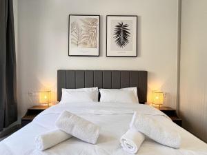sypialnia z białym łóżkiem z 3 obrazami na ścianie w obiekcie Chic Getaway Near Stavros Niarchos w Atenach