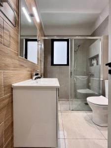 a bathroom with a sink and a toilet and a shower at Chic Getaway Near Stavros Niarchos in Athens