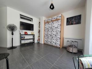 een woonkamer met een ventilator en een grote tegelvloer bij Appartement Salbris- Parking Gratuit in Salbris