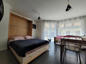 een slaapkamer met een bed en een tafel en stoelen bij Appartement Salbris- Parking Gratuit in Salbris